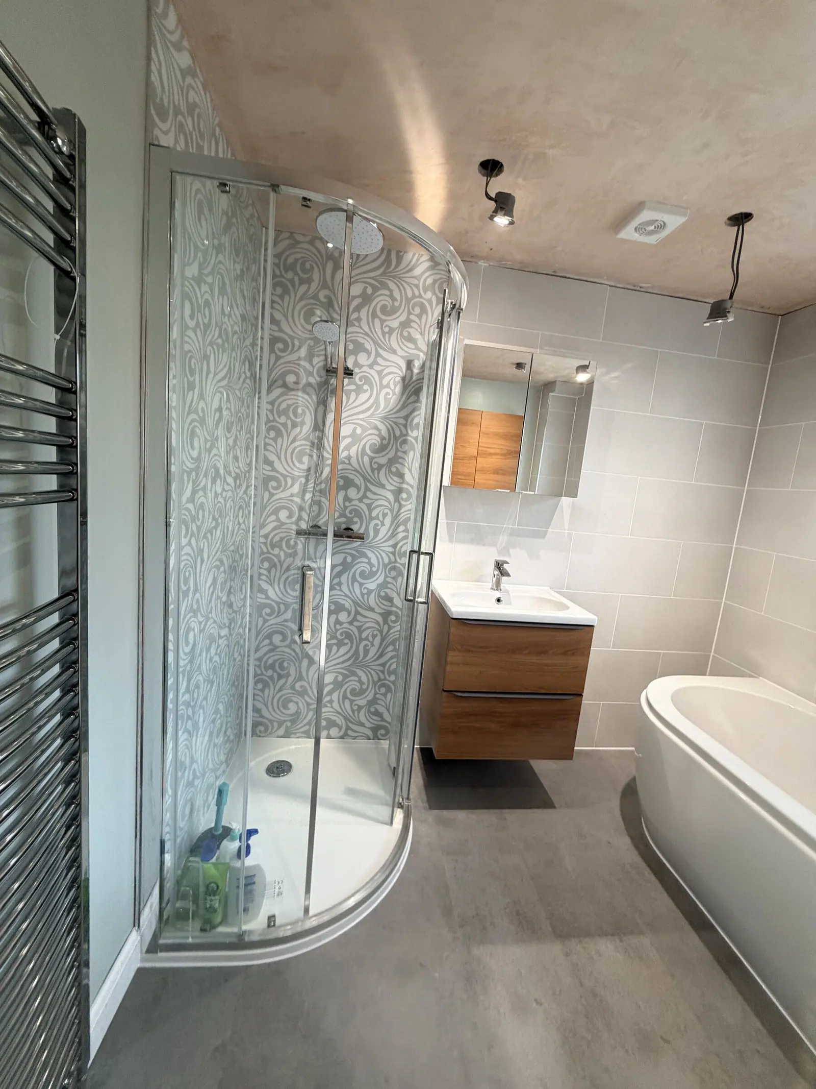 Bathroom with a quadrant shower, P-shaped bath, walnut vanity and sage green painted walls, fitted by Basingstoke Bathrooms
